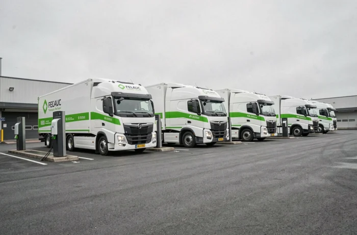 Flotte de camions électriques innovants d'un transporteur français alignés dans un dépôt de logistique durable en 2024